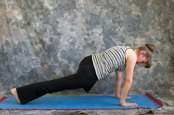 Vrouw doen yoga houding hoge plank knie aan elleboog — Stockfoto