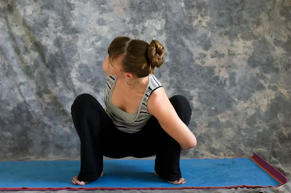 年轻女人在做瑜伽姿势绑定的 malasana 或花环蹲 p — 图库照片