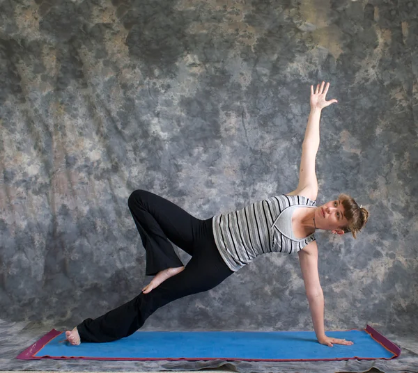 Jovem fazendo postura Yoga Vasisthasana ou prancha lateral pose v — Fotografia de Stock
