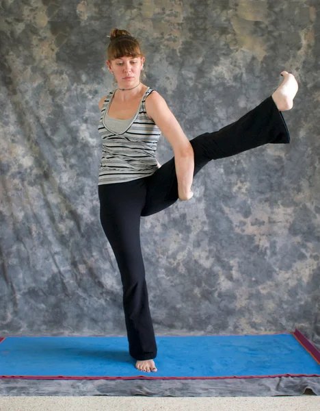 Kvinnan gör yoga posture paradisfågeln pose eller tittibhasana — Stockfoto