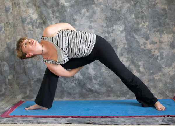 Mulher fazendo postura de Yoga amarrado ângulo lateral estendido pose esquerda — Fotografia de Stock