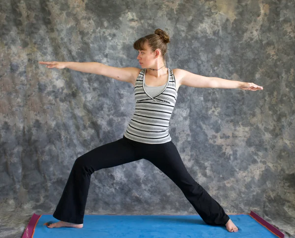 Woman doing Yoga posture Virabhadrasana II or warrior 2 pose — Stock Photo, Image