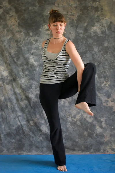 Mulher que entra na postura de Yoga Pássaro do Paraíso Pose ou Tittibhasan — Fotografia de Stock