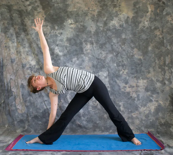 Jovem fazendo postura de Yoga Triângulo Pose ou Trikonasana — Fotografia de Stock