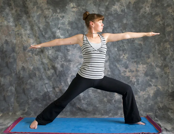 Jonge vrouw doen yoga houding virabhadrasana ii of warrior 2 po — Stockfoto