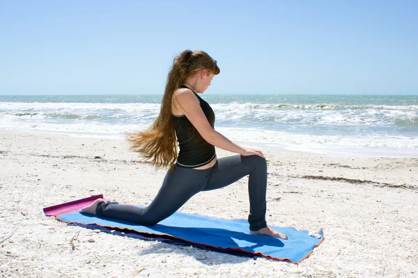 Woman doing yoga exercise on beach rotated Low Lunge or Ashwa Sa — Stock Photo, Image