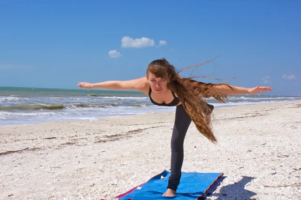 Kvinnan gör yoga övning flygplan hållning på stranden — Stockfoto