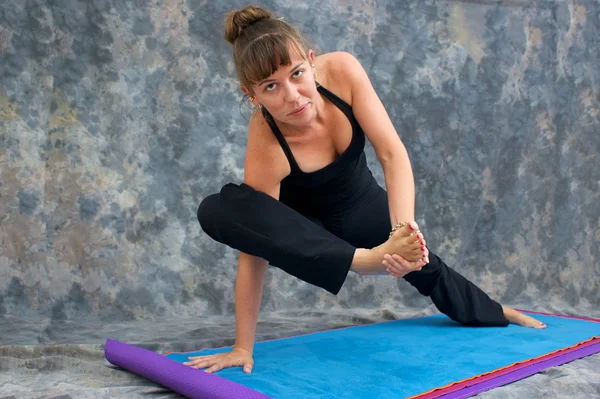 Frau macht Yoga-Übung sehr fortgeschrittene Ausfallhaltung gegen ein Mot — Stockfoto