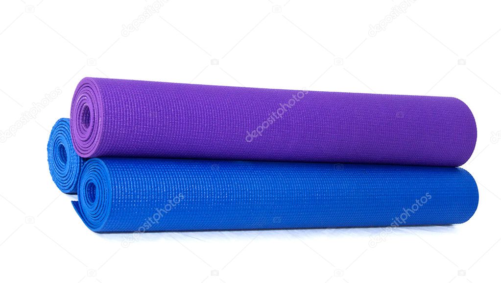 Three rolled exercise yoga mats stacked on white