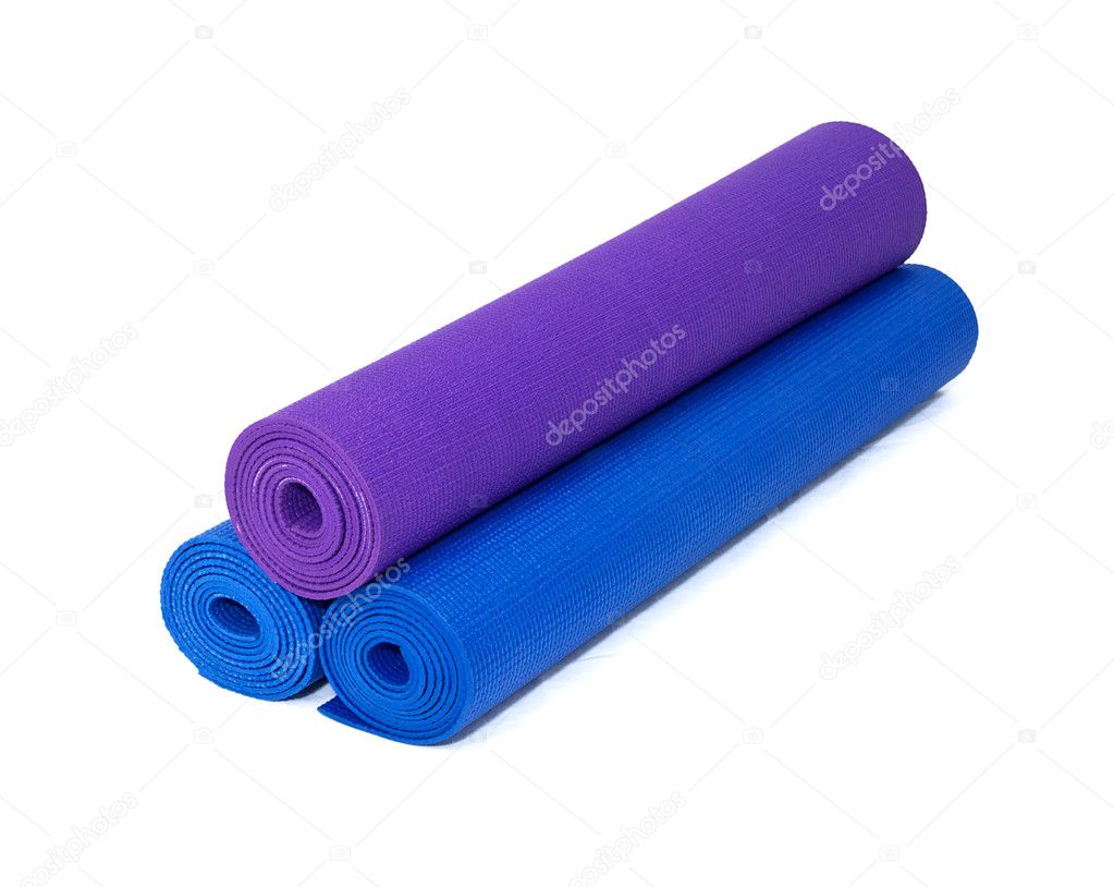 Three rolled yoga exercise mats stacked on white