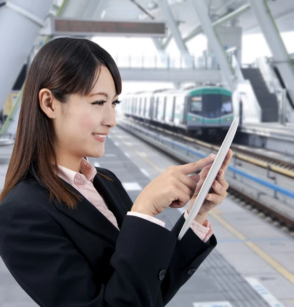 Jovem empresária usando touch pad na estação de trem — Fotografia de Stock