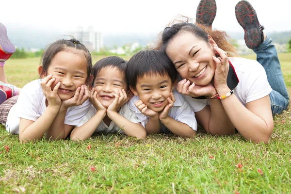 Mutlu anneler günü. Asya anne ve çocukları yeşil sahada — Stok fotoğraf