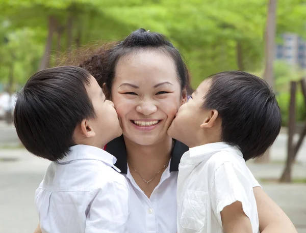 Feliz dia das mães. dois filhos beijando mãe — Fotografia de Stock