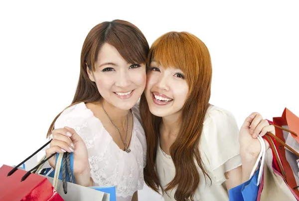 Happy young girls standing together with shopping bags — Stock Photo, Image