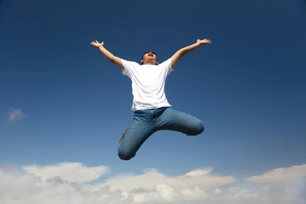 Homme heureux sautant avec fond bleu ciel — Photo