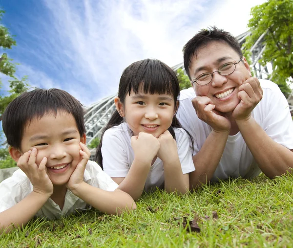 躺在 grass.father 上，儿子和女儿的家庭幸福 — 图库照片
