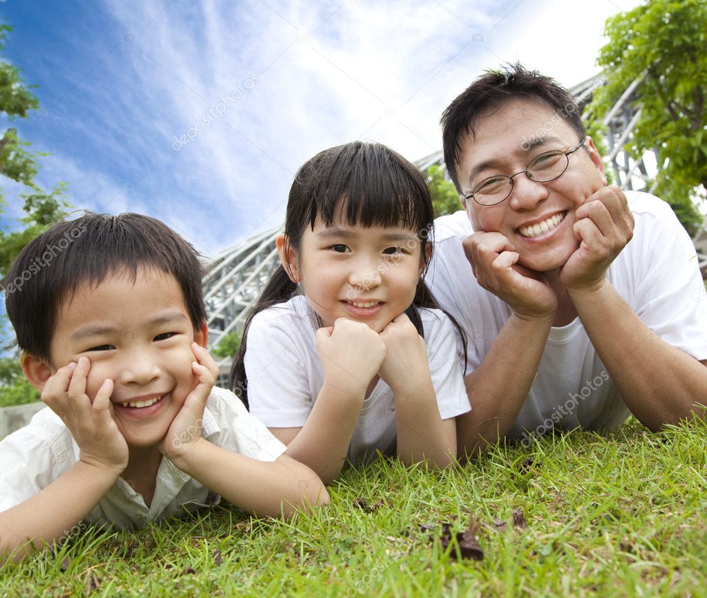 Happy family lying on the grass.father with son and daughter