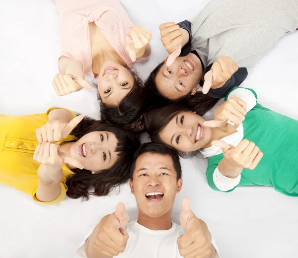 Group of asian young lying together with thumb up Stock Photo