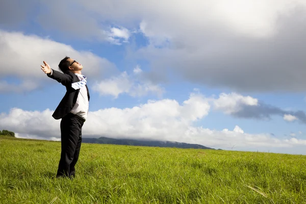 Young man in green field under blue skies Stock Photo