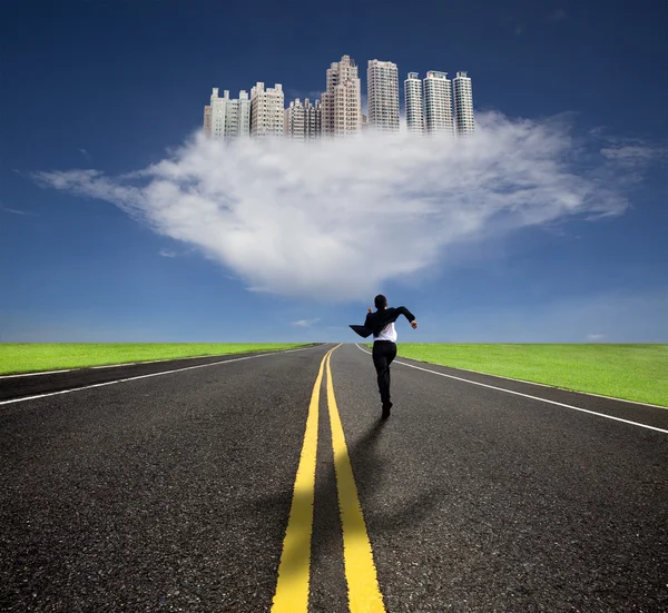 Empresario corriendo a la futura ciudad con su sombra — Foto de Stock