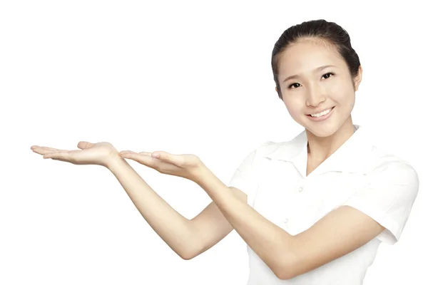 Lächelnd asiatische junge Frau zeigen Sie Ihr Produkt isoliert auf weiß — Stockfoto