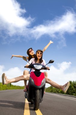 Happy young woman having summer trip on a scooter clipart