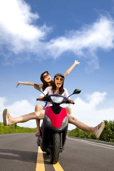 Happy young woman having summer trip on a scooter Stock Picture