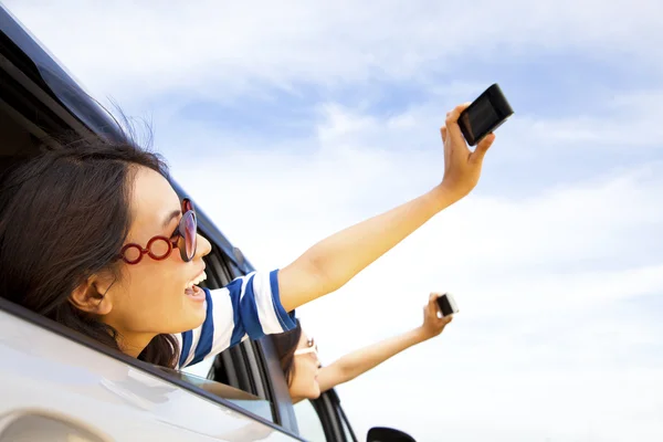 Молодая женщина с камерой и мобильным телефоном фотографирует — стоковое фото