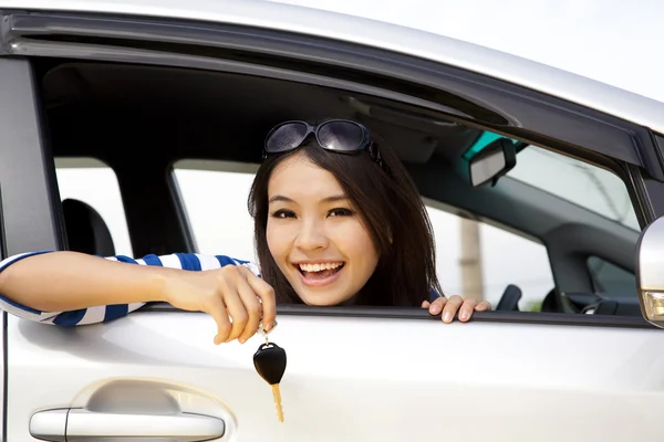 Jovem mulher feliz no carro mostrando as chaves — Fotografia de Stock