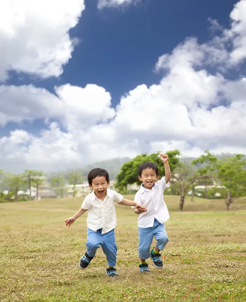 Çimenlerin üzerinde çalışan mutlu Asyalı çocuklar — Stok fotoğraf
