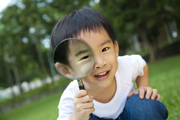 Happy kid with magnifying glass — Stock Photo, Image