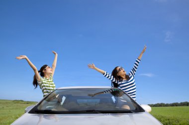 Two happy woman in the car and enjoy vacation clipart