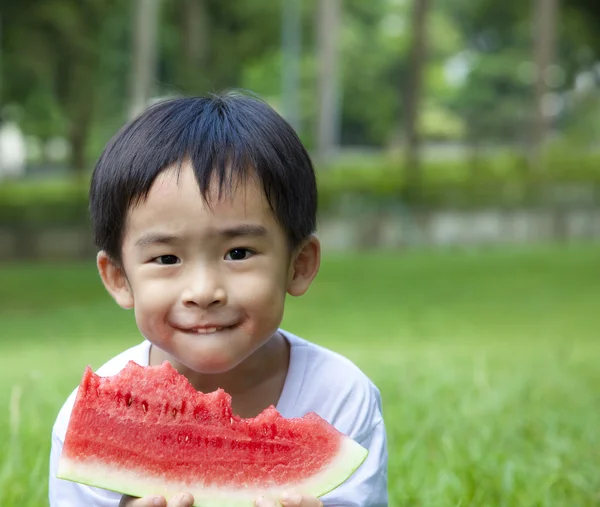 Mignon asiatique garçon manger pastèque — Photo