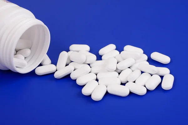 Gemorste tabletten en geneeskunde bottle.tablets op een blauwe achtergrond — Stockfoto