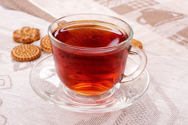 Чашка горячего чая и печенье на салфетке — стоковое фото
