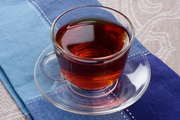 Kopp varm te på en mörk blå servett — Stockfoto