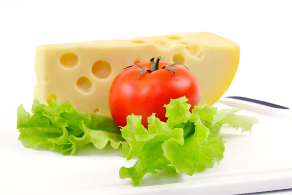 Queijo, tomate e salada em uma tábua branca — Fotografia de Stock