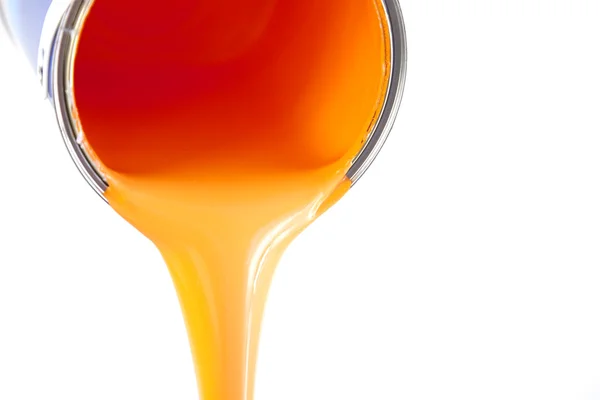 Orange paint flows from the bucket / isolated on white / photo — Stock Photo, Image