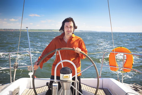 Jonge man is zeilboot kapitein — Stockfoto