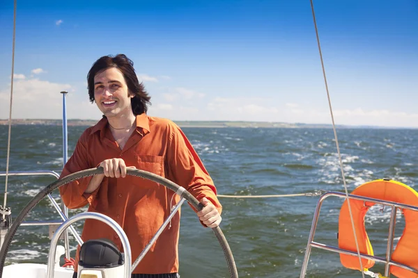 Young skipper driving sailboat — Stock Photo, Image