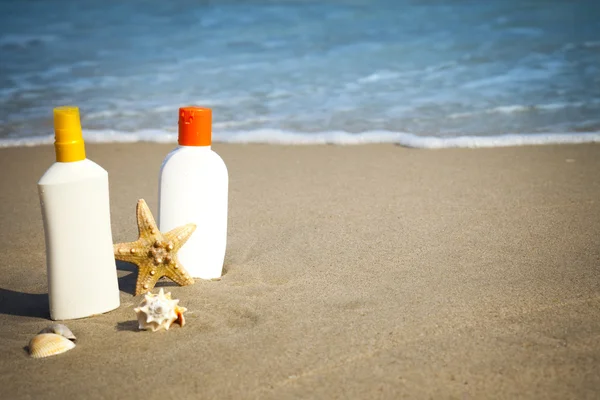 Suntan lotion Flacons på stranden med kopiplass – stockfoto