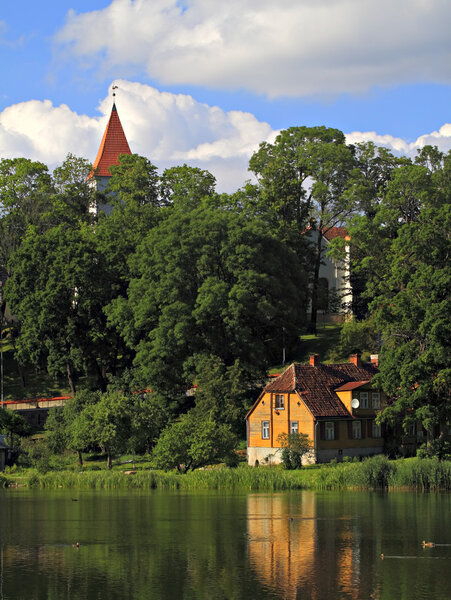 Church in Talsi city and old house by the lake.
