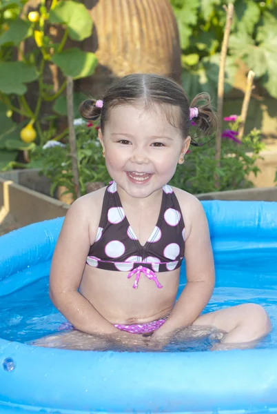 Boldog kis lány a medence Stock Kép