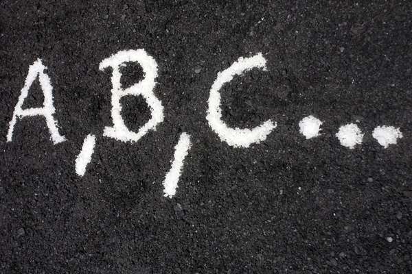 Білі літери a, b, c, написані на підлозі — стокове фото