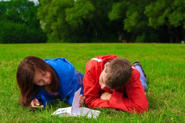 iki genç açık havada çim üzerinde okumak