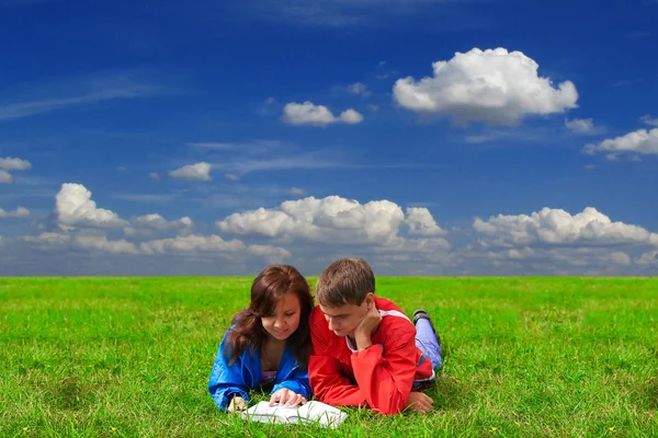 Two teenagers studying outdoors on grass — Stockfoto