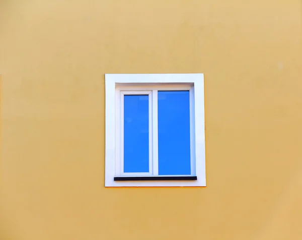 Вікно на жовтій стіні будинку — стокове фото