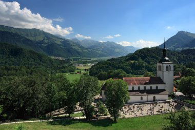 Church and mountains of Gruyeres Switzerland clipart