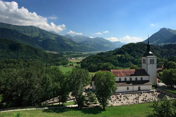 Egyház és a hegyek gruyeres-Svájc — Stock Fotó