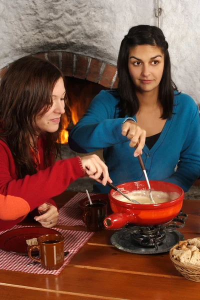 Women dipping bread into fondue — Stock Photo, Image